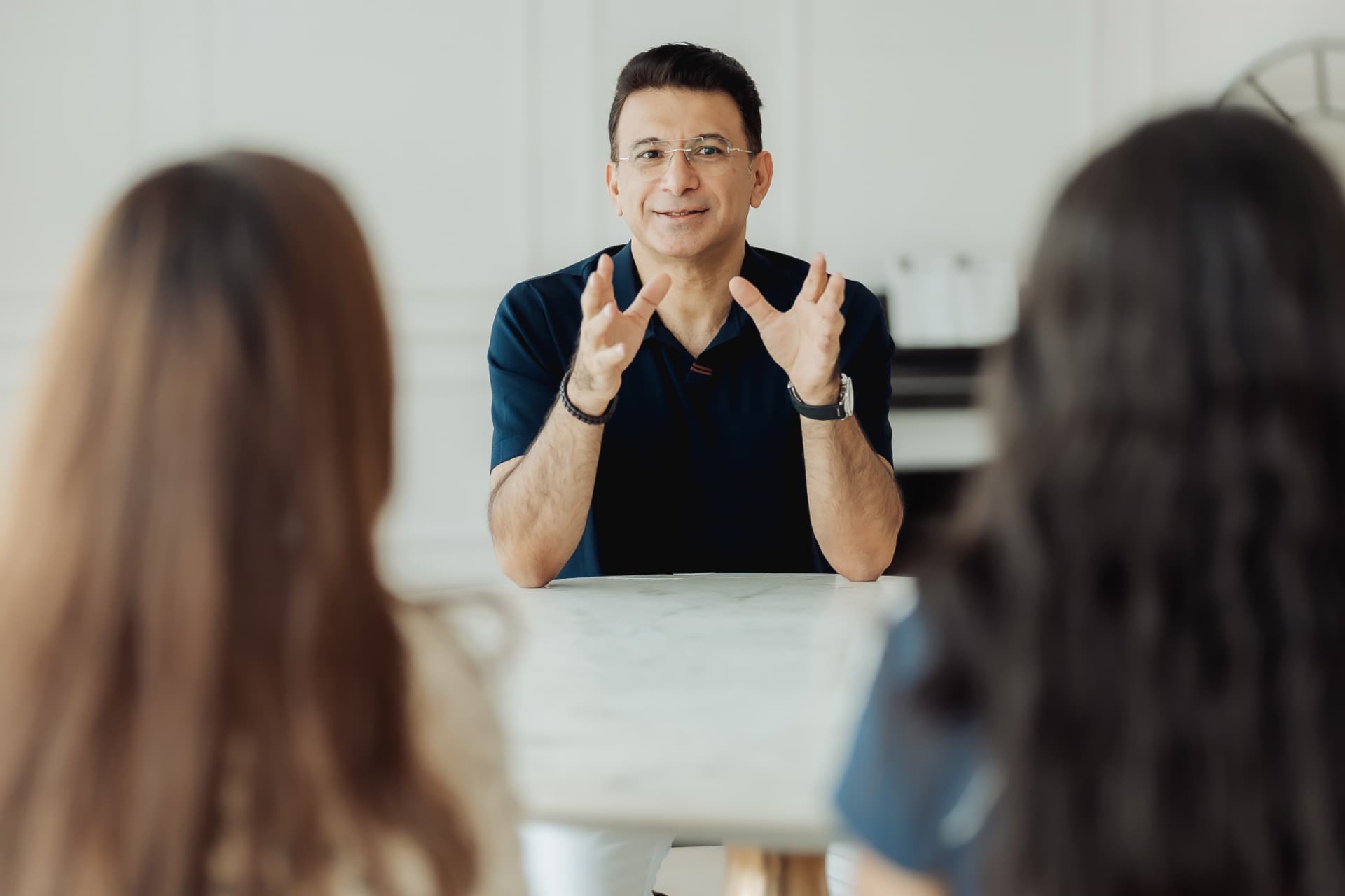 Dr. Sajid Burud in conversation with patients across a consultation table