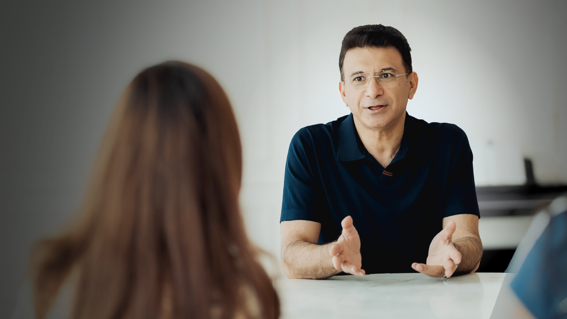 Dr. Sajid Burud in conversation with a patient across a consultation table